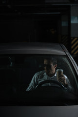 Wall Mural - male undercover agent in sunglasses sitting in car with paper cup of coffee