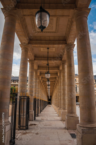 Fotografie, Obraz Pathway with marble colonnade between courtyards and cloudy sky at the Palais-Royal in Paris