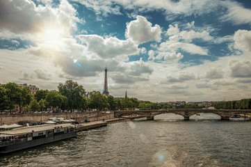 Wall Mural - Eiffel Tower, bridge and boat anchored at Seine River bank on sunset in Paris. Known as the “City of Light”, is one of the most impressive world’s cultural center. Northern France. Retouched photo.