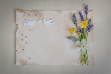 Spring Flowers With Paper For Text And Two Wooden Birds And Heart. Wedding, Engagement Or Betrothal Concept On On A Wooden Background.Copy Space, Top View. Greeting Card. Holiday Background.