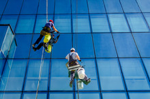 Industrial Climbers Are Applying Silicone On Joints Between Windows