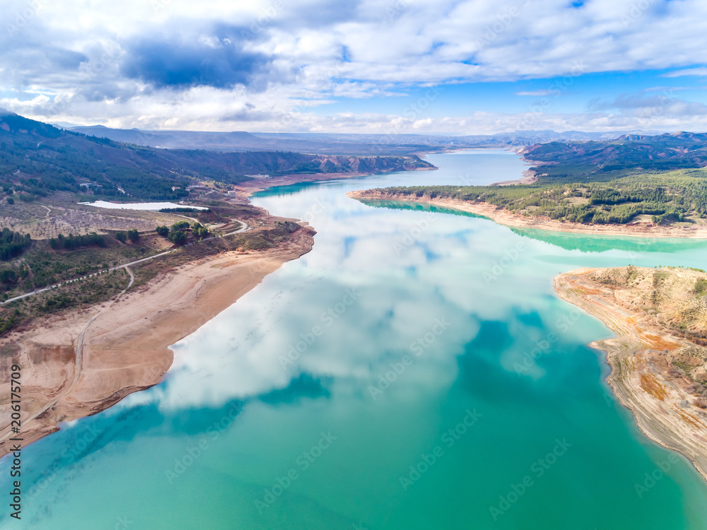 Aerial (drone) view of the "El Negratín" water reservoir, in Baza, Granada province, also known as "the interior sea". This is the third biggest water reservoir in Spain. - obrazy, fototapety, plakaty 
