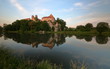 Opactow benedyktynów w Tyńcu pod Krakowem, widok z przeciwnego brzegu rzeki Wisły, w wodzie odbija się bryła budowli, skała, okoliczna roślinność