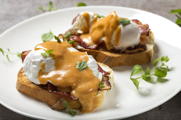 Eggs Benedict- toast, ham, poached eggs, and delicious buttery hollandaise sauce