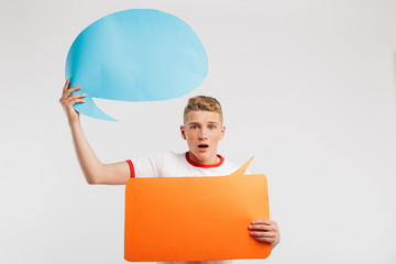 Sticker - Image of shocked male student wearing basic t-shirt holding two commercial placards copyspace for your text, isolated over white background