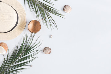 Summer composition. Tropical palm leaves, hat, coconut on pastel blue background. Summer concept. Flat lay, top view, copy space