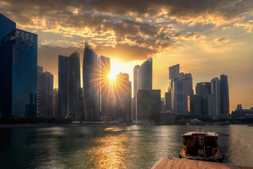 Wall Mural - Evening sunset on Marina bay in Singapore city with wooded boat and waterfront