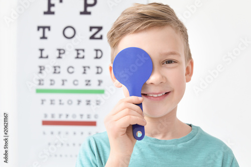 Fotomural Cute little boy near eye chart in ophthalmologist office