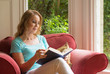 Attractive mature red headed woman enjoying reading a book