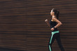© Prostock-studio - Young woman running in city copy space