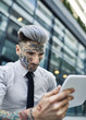 © Westend61 - Young businessman with tattooed face, using digital tablet
