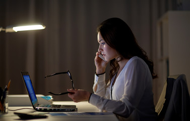 Canvas Print - business, technology, overwork, deadline and people concept - woman with laptop calling on smartphone at night office