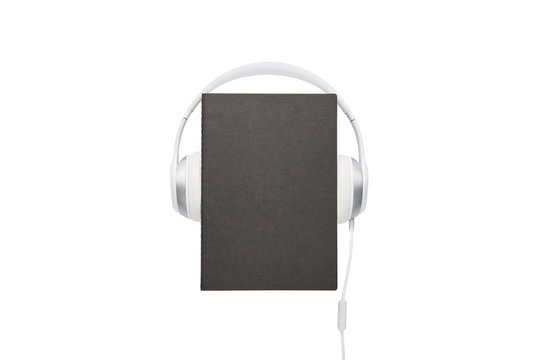 Audio book concept. Black book and white headphones set isolated on white background with copy space.