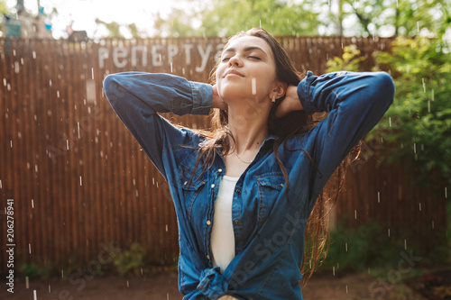 Cuadros en Lienzo Portrait of young beautiful lady in denim shirt dreamily closing her eyes while