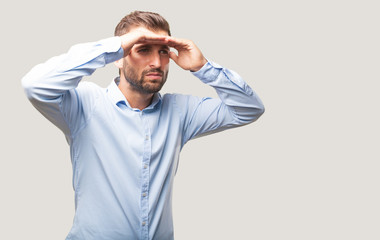 young handsome man looking far wearing blue t shirt, . person isolated against monochrome background