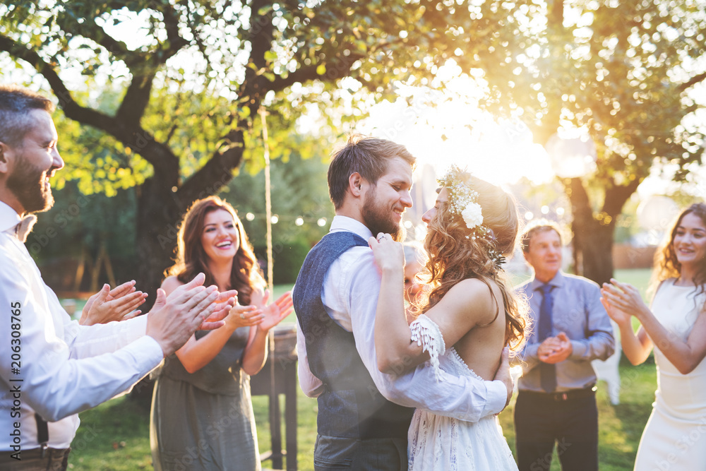 Bride and groom dancing at wedding reception outside in the backyard ...