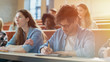 © Gorodenkoff - Hispanic Young Man Among His Fellow Students in the Classroom. Young Bright People Listening to a Lecture and Take Notes while Studying at the University.
