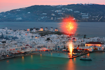 Wall Mural - Aerial view of Mykonos City, Chora with Old Port, white houses, windmilles and churches on the island Mykonos, The island of the winds, during evening blue hour, Greece
