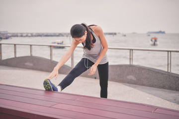 Sports concept. Beautiful girl is exercising on the beach with warm up. Beautiful girl is happy to exercise.