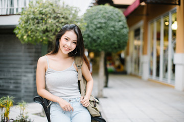 Summer sunny lifestyle fashion portrait of young stylish hipster woman walking on the street, wearing cute trendy outfit