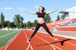 © silkstocking - Young woman doing sports at the stadium.