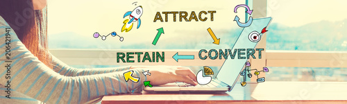 Fotografía Attract Convert Retain with woman working on a laptop in brightly lit room
