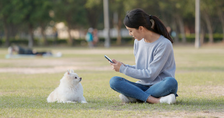 Canvas Print - Woman taking photo on her dog at outdoor park