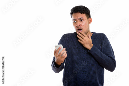Fotografía Studio shot of young Asian man holding mobile phone looking scar