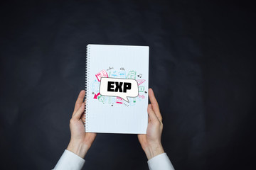 In the hands of a businessman a notebook with the inscription:EXP