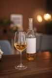 Fototapeta Lawenda - Glass and bottle of wine on table in restaurant