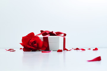 red rose and a little white box with a red ribbon