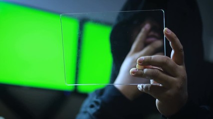 Poster - hacker using clear tablet with green screen monitor background