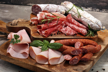 Wall Mural - Food tray with delicious salami, ham,  fresh sausages and herbs. Meat platter with selection