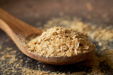 Closeup Of Nutritional Brewers Yeast Flakes In Wooden Spoon