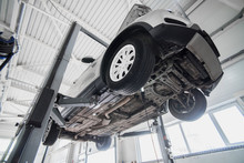 Car On A Wheel Alignment Lift In Auto Service. Diagnosis Of The Chassis Of The Car Raised At The Elevator.