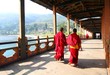 Two young monks walking on  PUNA MOCCHU BAZAM : Antique  wooden bridge at Punakha Dzong Monastery or Pungthang Dewachen Phodrang  Bhutan