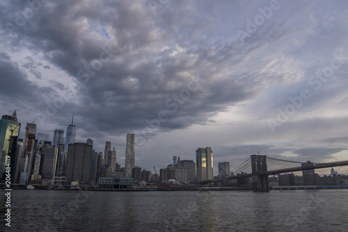 Fototapeta na szkło Amazing clouds over New York City skyline and Brooklyn Bridge on Hudson river