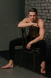 © Skripnik Olga - Casually handsome. Studio shot of handsome young man sitting on the chair and looking at camera. bare chest