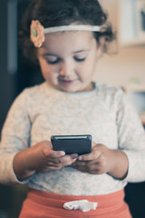 Wall Mural - Close up of small girl using smart phone.