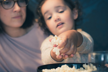 Wall Mural - Close up of daughter and mother eating popcorn.