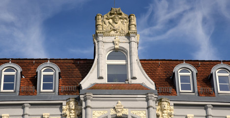 Reich geschmückter Giebel der Adler-Apotheke aus wilhelminischer Zeit auf dem Marktplatz von Senftenberg vor strahlend blauem Himmel