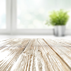 Wall Mural - empty shabby chic wooden styled table with copy space for products and blurred green potted plant in