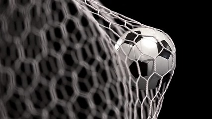 Beautiful soccer ball flies into net on a black background. The movement at the beginning is accelerated then slowly