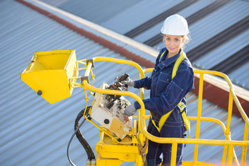 female construction worker on site in hydraulic lifting ramp