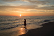 Girl standing at the edge of the water at sunset in Captiva Island