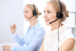 © rogerphoto - Bright  call center office. Two blonde women in a headset