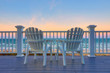 Adirondack Chair sits on the balcony deck of a house looking out over the beach and the ocean