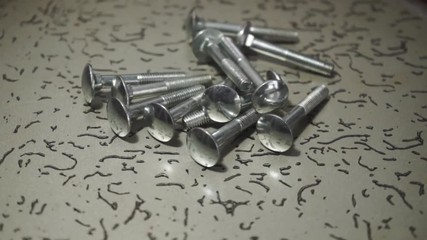 Poster - Bolts rotating on a metal table and black background. 