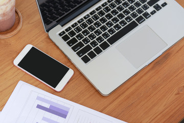 laptop and tablet with social network diagram and two colleagues discussing date on desk as concept