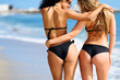 © javiindy - Rear view of two young women with beautiful bodies in bikini